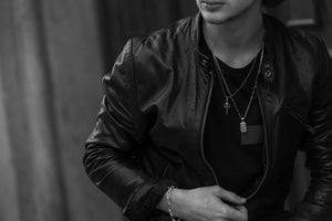 A chic black and white picture of a man in a leather jacket showcasing pieces of Argento Milano's first collection on Argento Milano's Home Page.